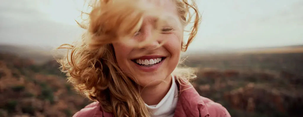 Woman smiling while wind is playing with her hair