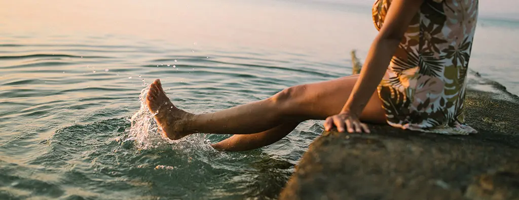 Woman splashing her foot into the sea