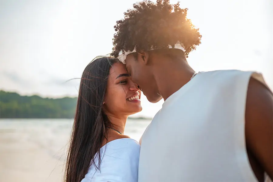 A young woman and a young man touch each others head