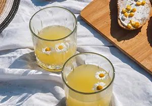 Beverage with floating camomile flowers