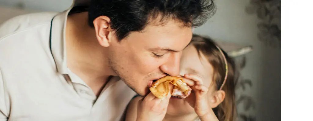 Girl feeding dad a pancake