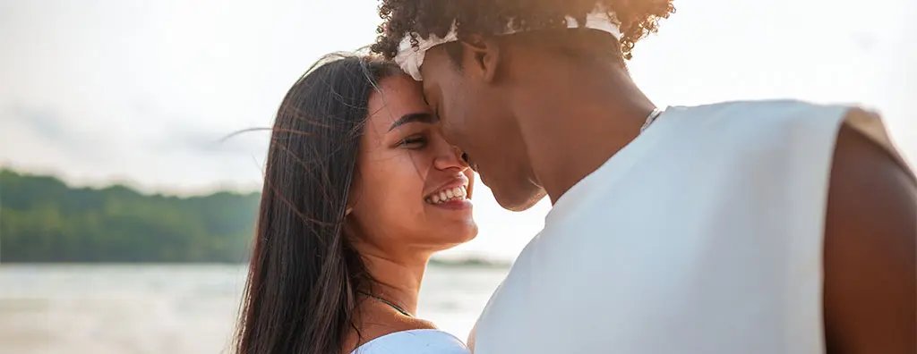 A young woman and a young man touching each others head
